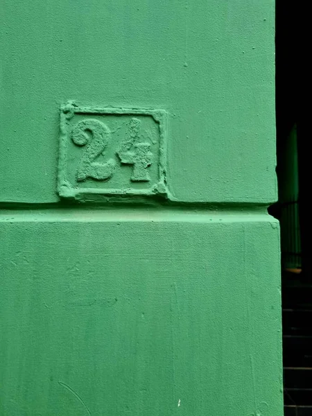 緑の塗料で覆われた壁に 記号の垂直ショット屋外 — ストック写真