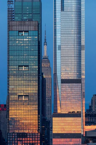 日没時に2つの新しい高層ビルの間に囲まれた有名なSpire State Building — ストック写真