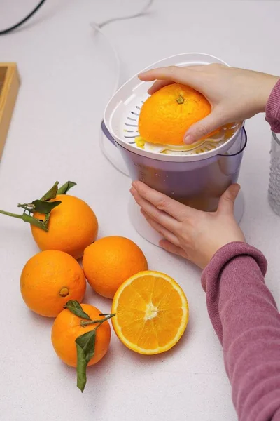 Vrouw Handen Knijpen Sinaasappels Een Sapcentrifuge Haar Keuken Thuis — Stockfoto