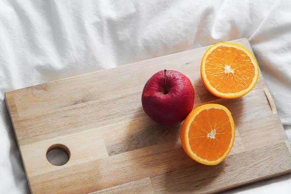 Zbliżenie Wyciętej Pomarańczy Jabłkiem Pokładzie Białym Łóżku — Zdjęcie stockowe