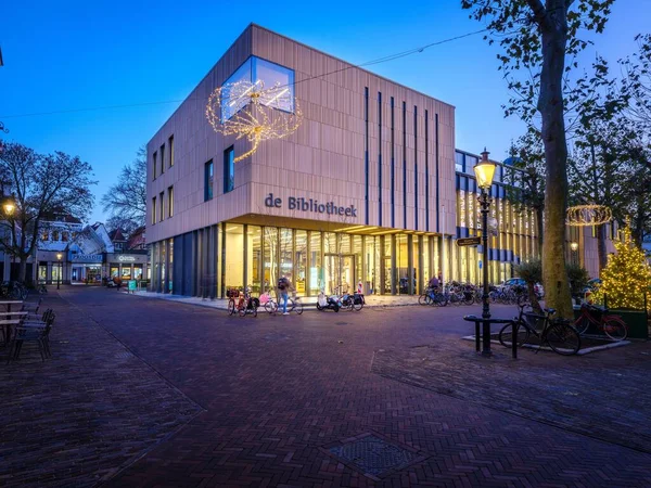 Deventers Bibliotek Den Blå Timen Folk Med Sykler Foran Nederland stockbilde