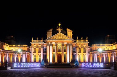 The illuminated Blenheim Palace with Christmas lights at night in England clipart