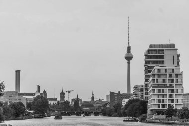 Berlin, Almanya 'da bulutlu gökyüzünün altındaki nehrin karşısındaki inşaatın manzara görüntüsü.