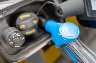 A closeup of a car filling up with diesel at a petrol station clipart
