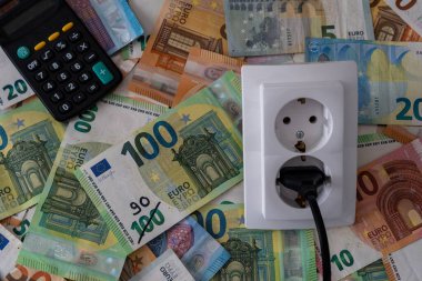 Avro banknotunda bir elektrik prizi para ve hesap makinesi, artan elektrik fiyatları krizi