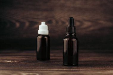 Kahverengi cam şişelerdeki CBD yağlarına yakın çekim.