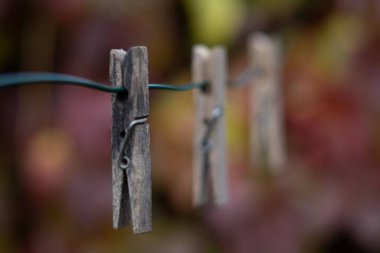 Clothespin satırının bulanık arkaplana karşı bir tel üzerinde asılı seçici bir odak çekimi