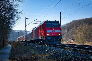 Ağaçlarla çevrili demiryolunda bir tren.