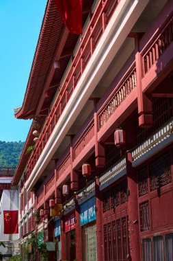 Mavi gökyüzünün altında kırmızı duvarları olan geleneksel Çin mimari cephesinin yan tarafı.