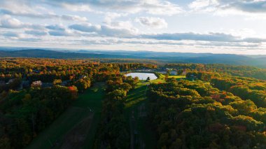 Sonbahar yeşillikleri sonbahar renkleriyle kaplı sık bir ormanla kaplı bir dağlık arazi.