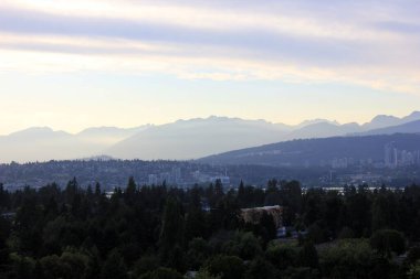 Dağların katmanları ve sabah güneşinin altındaki şehir manzarası, Vancouver, Kanada