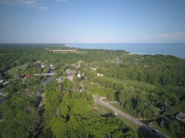Yoğun ağaçlarla çevrili köyün havadan görüntüsü.
