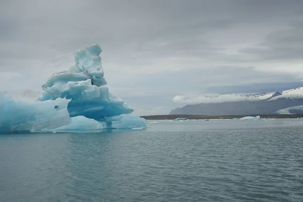 アイスランドのジョクルサロン氷河湖の表面に浮かぶ大きな青い氷山 — ストック写真