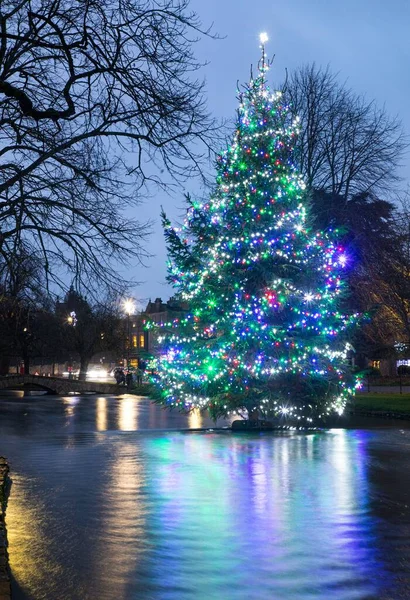 stock image The colorful decorated Christmas tree in the river at Bourton-on-the-Water in The Cotswolds