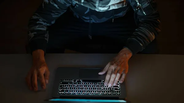 机に座ってノートパソコンで作業してる男 — ストック写真