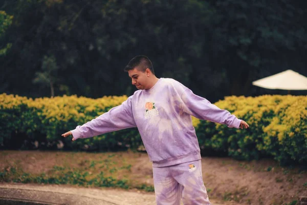 一个身穿紫色领带染料运动服的西班牙年轻人在公园里 — 图库照片