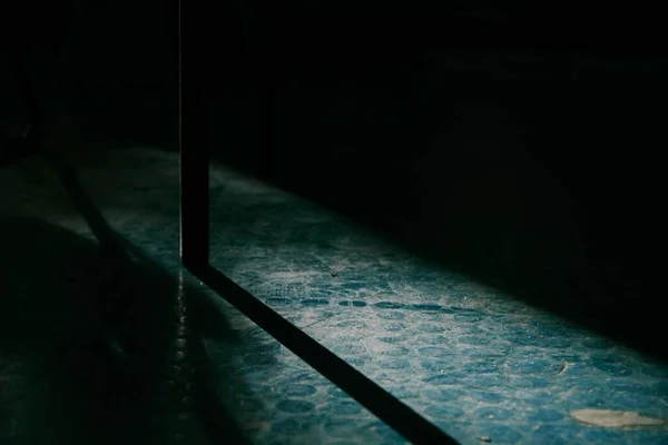 Karanlık Odadaki Kirli Masa Tabanının Uzun Gölgesinin Yakın Çekimi — Stok fotoğraf