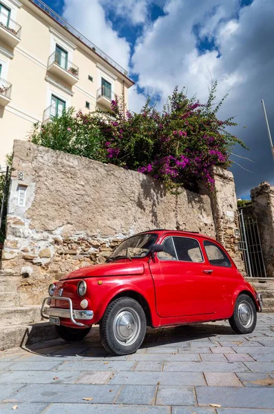 Pionowe Ujęcie Czerwonego Samochodu Fiat Zaparkowanego Przed Starą Ścianą Mieście — Zdjęcie stockowe