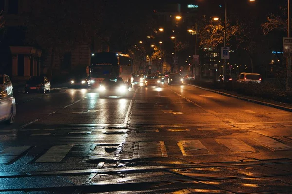 在维也纳 一条被雨淋湿的街道反射着夜晚的车灯 — 图库照片