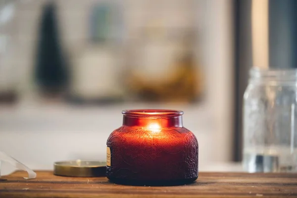 Eine Kerze Einem Roten Glasbehälter Auf Dem Holzbrett — Stockfoto
