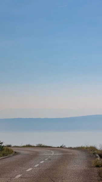位于克罗地亚达尔马提亚的一条以大海为背景的道路的垂直截图 — 图库照片