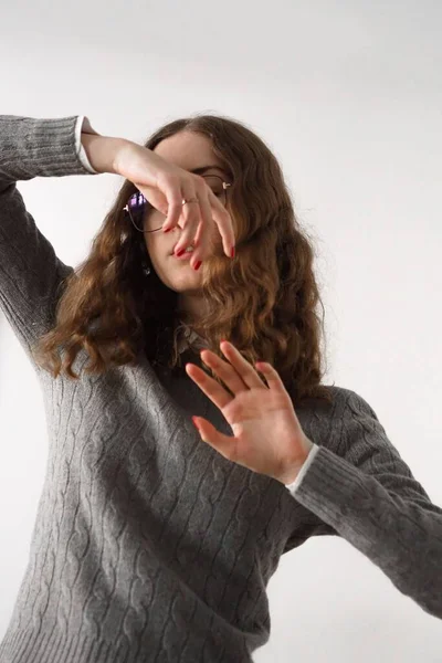 stock image A Caucasian woman wearing gray sweater posing in white background