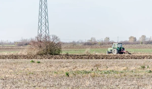 Ein Grüner Traktor Fährt Bei Der Ernte Durch Ein Feld — Stockfoto
