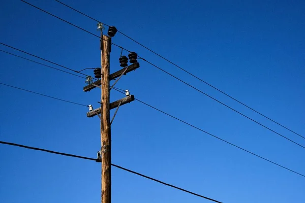 蓝天电线杆在蓝天背景上带有金属丝的电线杆的低角度拍摄 — 图库照片