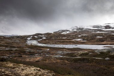 Norveç 'teki Hardangervidda Ulusal Parkı boyunca 7. yolun yakınındaki karlı karlı arazinin hava görüntüsü.