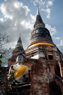 Ayutthaya, Tayland 'da iki pagoda önünde Buda heykelinin dikey çekimi..