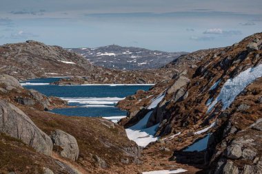 Norveç, Lyseveien 'deki kayalık dağların yakınındaki mavi suyun hava manzarası.