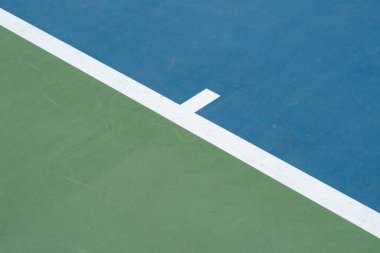 Güneşli bir günde mavi ve yeşil tenis kortunun manzarası