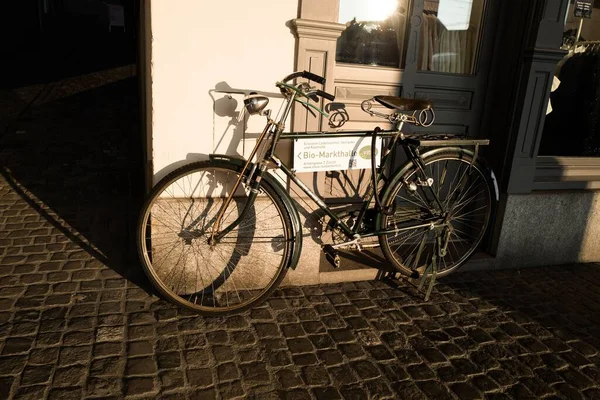 瑞士苏黎世大街上一辆黑色旧自行车靠在墙上的水平截图 — 图库照片