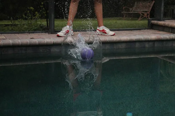 Boll Stänk Poolen Vatten Bakgrunden Benen Person Som Står Vid — Stockfoto