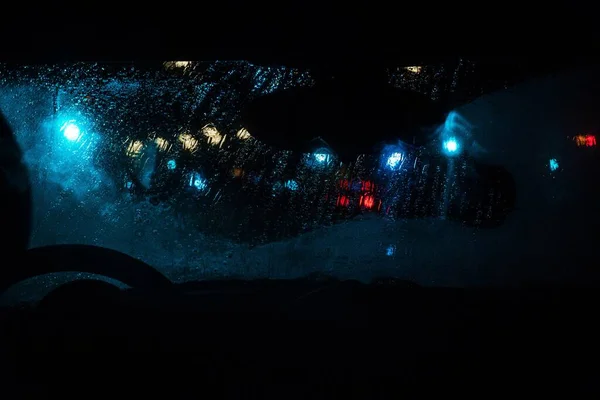 从司机的角度看一条多雨的模糊街道的夜景 — 图库照片