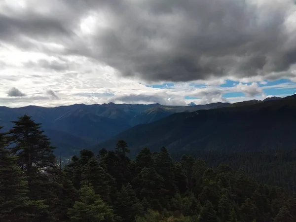 stock image A beautiful scene of green mountains under dark cloudy sky, landscape background