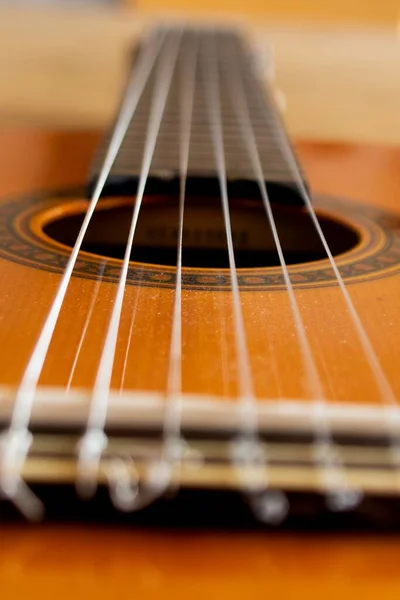 Eine Vertikale Aufnahme Einer Braunen Gitarre Auf Dem Verschwommenen Hintergrund — Stockfoto