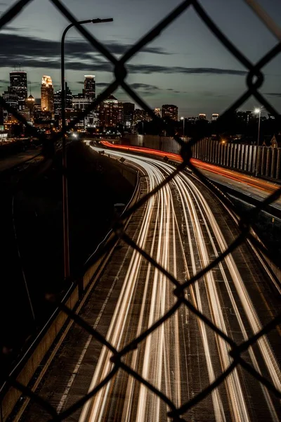 Vertikální Záběr Asfaltové Silnice Dlouhými Expozičními Světly Vidět Přes Kovové — Stock fotografie