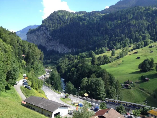 İsviçre 'de bir yolun arka planındaki manzaralı yeşil dağlar