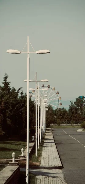 Μια Κάθετη Βολή Των Φανών Του Δρόμου Ένα Τροχό Ferris — Φωτογραφία Αρχείου