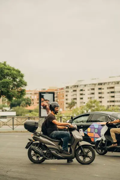 西班牙塞维利亚大街上一个骑摩托车的男子的垂直镜头 — 图库照片