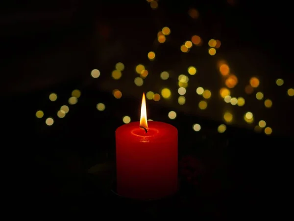 在黑暗的Bokeh背景上 一张燃烧的红色蜡烛的特写照片 — 图库照片