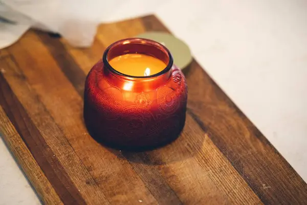 Eine Duftkerze Einem Roten Glas Auf Einem Holzbrett — Stockfoto