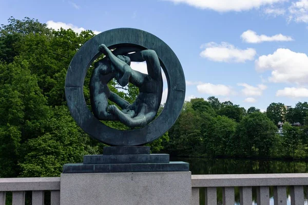挪威奥斯陆维格兰公园的一座现代雕塑在绿树成荫的蓝天下被捕获 — 图库照片