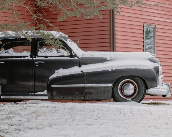 Крупный План Черной Классической Машины Припаркованной Сосеной Покрытой Снегом Рядом — стоковое фото