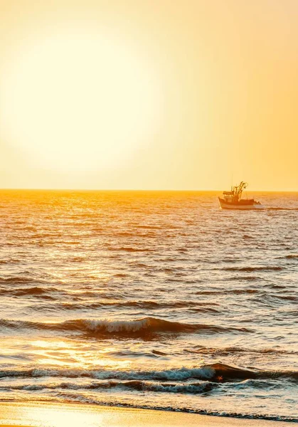 Vertikl Vzdálené Lodi Plavbě Vlnitém Moři Proti Zářícímu Západu Slunce — Stock fotografie