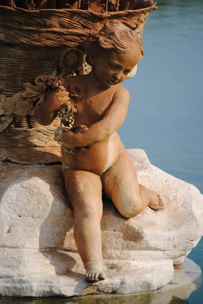 Brązowy Marmur Dziecka Rzeźbiony Posąg Przy Fontannie Pionowy Strzał — Zdjęcie stockowe
