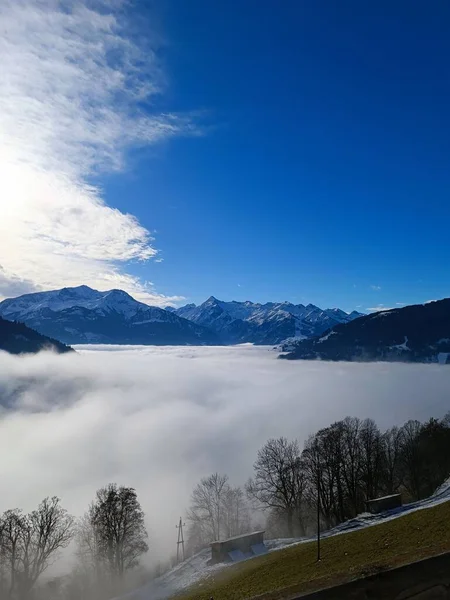 Pionowy Strzał Twierdzy Dolina Pokryta Gęstą Mgłą Pod Błękitnym Niebem — Zdjęcie stockowe