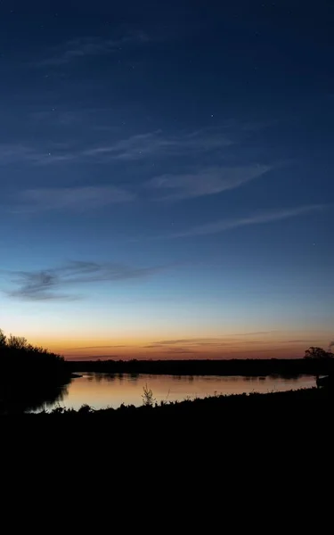 美丽的夕阳西下的河畔景色和树木的轮廓 — 图库照片