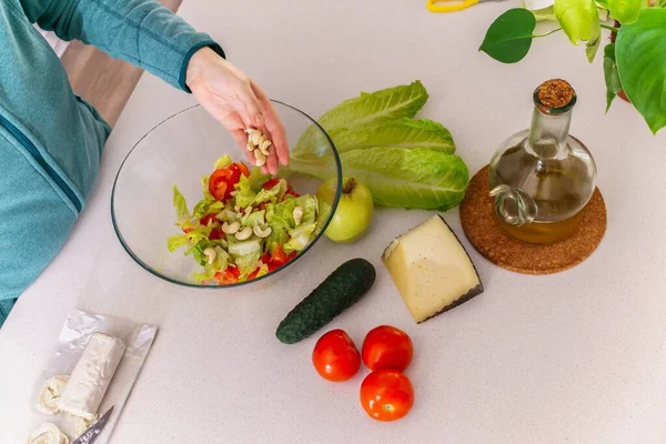 Woman Adding Cashews Healthy Salad Her Kitchen Table —  Fotos de Stock